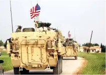  ??  ?? US forces, accompanie­d by YPG fighters drive their armored vehicles near the northern Syrian village of Darbasiyah, on the border with Turkey. (File photo/AFP).