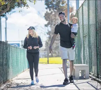  ?? Gina Ferazzi Los Angeles Times ?? JULIUS RANDLE WALKS with wife Kendra and their 1-year-old son Kyden at a Manhattan Beach park. “For me it’s been absolutely amazing,” he says of being a father. “The highlight of my day, every day.”