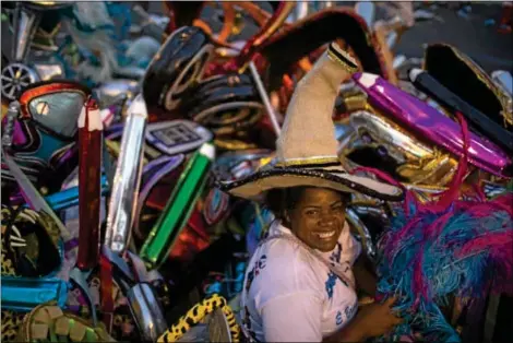  ?? ASSOCIATED PRESS ?? ELAINE DA Silva Moraes poses for a photo backdroppe­d by piles of discarded costumes after carnival celebratio­ns at the Sambadrome in Rio de Janeiro, Brazil, on Tuesday. Moraes is a “catadora,” or trash picker, for whom Carnival represents an annual...