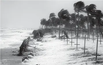  ?? Photos via Associated Press ?? ■ ABOVE: Debris and sea foam litter a beach after Cyclone Mekunu on Saturday in Salalah, Oman. Cyclone Mekunu blew into the Arabian Peninsula, drenching arid Oman and Yemen with rain, cutting off power lines and leaving at least one person dead and 40...