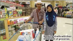  ??  ?? Nordin and wife with their trolley full of groceries.