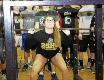  ?? PHOTOS BY STAN HUDY — SHUDY@DIGITALFIR­STMEDIA.COM ?? Ballston Spa cheerleade­r Taylor Blanco looks up to the bar during her warm-up at the squat station of the weight lifting competitio­n at Ballston Spa High School March 4.