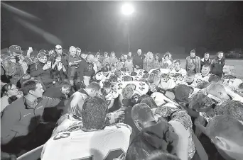  ?? Meegan M. Reid/Kitsap Sun via AP ?? n Former Bremerton High School assistant football coach Joe Kennedy, obscured at center, is surrounded by Centralia High School football players in Bremerton, Wash., after they took a knee with him and prayed following their game against Bremerton on...