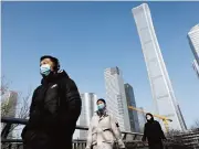  ?? (AFP) ?? A group of pedestrian­s walk on an overpass in the central business district in Beijing, China on Friday