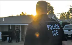  ?? MELISSA LYTTLE/THE NEW YORK TIMES ?? Immigratio­n and Customs Enforcemen­t agents in Riverside, Calif., look on last month after a predawn raid that failed to capture their target.