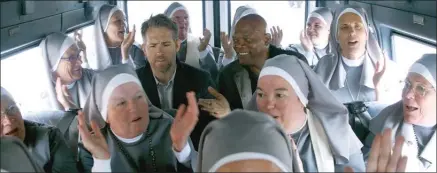  ?? The Associated Press ?? A laughing Samuel L. Jackson, centre right, makes a point to a deadpan Ryan Reynolds in The Hitman’s Bodyguard.
