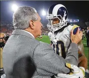  ?? CURTIS COMPTON / CCOMPTON@AJC.COM ?? Falcons owner Arthur Blank embraces Rams running back Todd Gurley, a former UGA star, after the Falcons’ wildcard win in 2018.