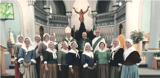  ?? —photo fournie ?? Archevêque Mgr Marcel Damphousse, curé Mgr Léo Villeneuve, diacre permanent Michel Miner, entourés de la chorale des Filles du Roy.