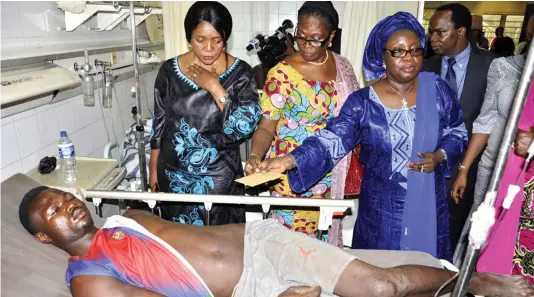  ?? PHOTO ?? House of Reps. Leader, Mulikat Akande Adeola (right) giving financial assistance to a victim of Monday’s Abuja blast at the National Hospital in Abuja yesterday. With her, from left, are Betty Apiafi and Stella Dogu. MACJOHN AKANDE