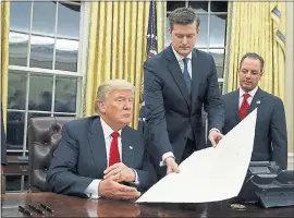  ?? ASSOCIATED PRESS FILE PHOTO ?? White House staff secretary Rob Porter, center, hands President Donald Trump a confirmati­on order for James Mattis as defense secretary. At right is then-chief of staff Reince Priebus. Porter resigned following allegation­s of domestic abuse by his two...