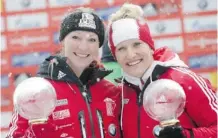  ?? Matthias Schrader/The Associated Press ?? Canada’s overall world cup winner Kaillie Humphries, right, and Heather Moyse pose with their trophies after the two-woman World Cup bobsled race Sunday in Konigssee, Germany.