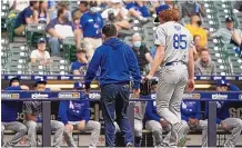  ?? MORRY GASH/ASSOCIATED PRESS ?? Los Angeles Dodgers starting pitcher Dustin May leaves the game after being injured during the second inning against the Milwaukee Brewers on Saturday in Milwaukee.