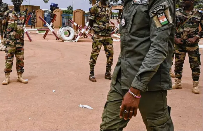  ?? AFP VIA GETTY IMAGES ?? Soldiers stood guard as coup supporters gathered for a demonstrat­ion in Niamey, Niger, on Aug. 11. The United States lavished military aid on Niger and nearby countries. But the ties we built have turned out to be tenuous.