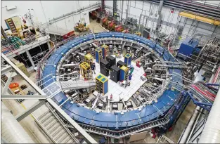  ?? REIDAR HAHN — VIA THE ASSOCIATED PRESS ?? The Muon g-2ring at the Fermi National Accelerato­r Laboratory outside of Chicago in August 2017, with an unidentifi­ed person. The ring detects the wobble of muons as they travel through a magnetic field.