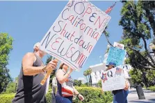  ?? RICH PEDRONCELL­I/ASSOCIATED PRESS ?? Protesters calling for the end of Gov. Gavin Newsom’s stay-at-home orders march around the state capitol in Sacramento, Calif. More Americans disapprove than approve of protests against restrictio­ns.