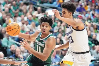  ?? PAUL SANCYA/ASSOCIATED PRESS ?? Michigan State guard A.J. Hoggard (11) drives on Marquette forward Oso Ighodaro (13) in the first half of the Spartans’ 69-60 win. Michigan State returns to the Sweet 16 for the first time since 2019.