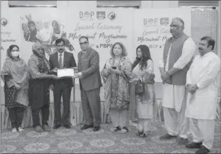  ??  ?? LAHORE
Zafar Masud, President & CEO The Bank of Punjab presenting a shield to Ms Beenish Fatimah Sahi, CEO Punjab Social Protection Authority. -PR