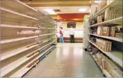  ?? Juan Barreto AFP/Getty Images ?? EMPTY SHELVES are common. At one similarly stocked market, the posted slogan “An achievemen­t of the revolution!” seemed unintentio­nally mocking.