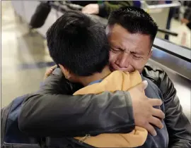  ?? RINGO H.W. CHIU — THE ASSOCIATED PRESS ?? David Xol-Cholom of Guatemala hugs his son Byron at Los Angeles Internatio­nal Airport on Wednesday as they reunite after being separated since May 2018 during the Trump administra­tion’s wide-scale separation of immigrant families.