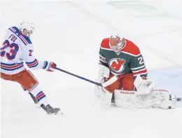  ?? ANDREW MILLS/AP ?? Rangers defenseman Adam Fox (23) beats Devils goaltender Mackenzie Blackwood (29) to score a goal during the first period Saturday in Newark N.J.