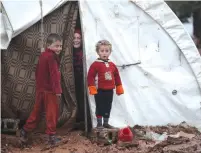  ??  ?? SYRIAN REFUGEE children stand last month near their tent in the Bab Al-Salam camp near the Syrian-Turkish border.