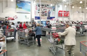  ?? — Reuters ?? People are seen inside shopping at a Costco Wholesale warehouse club in Westbury, New York.