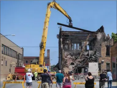  ?? ERIC BONZAR — THE MORNING JOURNAL ?? Bystanders watch as B & B Wrecking demolishes the Thistle building at 700 Broadway Ave., Aug. 15.