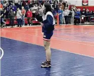  ?? Contribute­d photo ?? Foran junior Kelly Aspras sings the National Anthem before the start of the Queen of the Mat girls wrestling tournament at Foran on Sunday. Aspras won the 145-pound weight class with three pins.