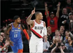  ?? STEVE DIPAOLA — THE ASSOCIATED PRESS ?? Portland Trail Blazers guard Damian Lillard, right, reacts after making a basket as Oklahoma City Thunder forward Paul George, left, trails the play during the first half of Game 1 of a first-round NBA basketball playoff series in Portland, Ore., Sunday.