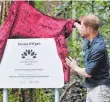  ?? FOTO: AFP ?? Technik vom Papa, Humor vom Opa: Prinz Harry enthüllt überaus gekonnt eine Plakette.