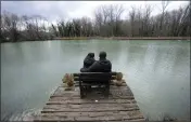  ?? DARKO VOJINOVIC — THE ASSOCIATED PRESS ?? Mariia Vyhivska, from Ukraine, left, and Iurii Kurochkin, from Russia, sit on the bench on the banks of the Ada Safari Lake in Belgrade, Serbia, on Feb. 5.