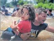  ?? REUTERS ?? A file photo of a migrant from Honduras holding his daughter while crossing the Suchiate River into Mexico from Guatemala.