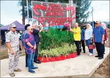  ?? ?? Ting (centre right) and Yii jointly perform the ribbon-cutting ceremony to mark the start of Pesta Bubuk at Kampung Batu Satu.