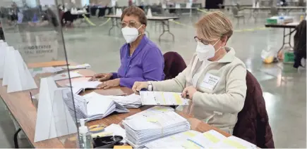  ?? MIKE DE SISTI / THE MILWAUKEE JOURNAL SENTINEL ?? Election workers Kathy Prodoehl, right, and Marion Fields count some of the 386 unopened absentee ballot envelopes that were found Tuesday during the presidenti­al election recount in Milwaukee.