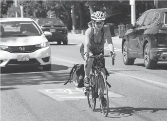  ?? WAYNE CUDDINGTON ?? A cyclist rides along Holland Avenue near the Queensway overpass. The city put cycling sharrows in the middle of each side of the road but many said this was too dangerous, so the city changed its mind.