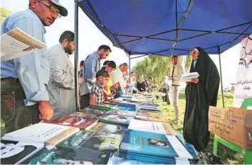  ?? AFP ?? War-weary residents choose literature that wiill help them forget the violence at an annual literary festival held at Abu Nawas street, along the Tigris river in Baghdad, on Saturday.