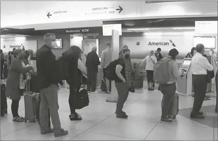  ?? LOANED PHOTO ?? PEOPLE WAIT IN LINE at an American Airlines counter at an airport in Charlotte, N.C. on Sunday.