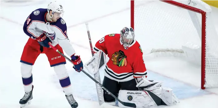  ?? KAMIL KRZACZYNSK­I/AP ?? Blackhawks goaltender Cam Ward stops Blue Jackets center Sam Vigneault in the third period Saturday night at the United Center. Ward had 16 saves on 17 shots against Columbus.