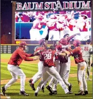  ?? NWA Democrat-Gazette/BEN GOFF ?? Arkansas players mob Evan Lee after he scored the winning run in the bottom of the 10th inning in the Razorbacks’ 5-4 victory over Georgia on Friday night at Baum Stadium in Fayettevil­le.