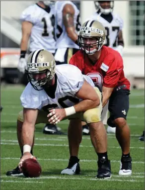  ??  ?? Under center: New Orleans Saints quarterbac­k Drew Brees, right, lines up behind center Max Unger during training camp in White Sulphur Springs, W.Va., on Thursday.