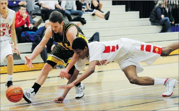  ?? JASON PAYNE — PNG FILES ?? Six-foot-nine forward Tristan Etienne (right) lunges for a loose ball against Kelowna Owls guard Mitchell Goodwin during a semifinal game of the Terry Fox Legal Beagle Invitation­al basketball tournament in Port Coquitlam on Jan. 6.