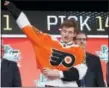  ?? MICHAEL AINSWORTH — THE AP ?? Joel Farabee puts on a jersey after being selected by the Philadelph­ia Flyers during the NHL hockey draft in Dallas, Friday.