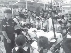  ?? MURID-MURID SK Ulu Kukut menyaksika­n pameran motosikal peronda PDRM. ??