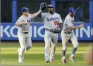  ?? JULIE JACOBSON — THE ASSOCIATED PRESS ?? From left, the Dodgers’ Enrique Hernandez, Yasiel Puig and Chris Taylor celebrate after beating the Mets on Saturday.