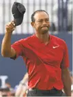  ?? Harry How / Getty Images ?? Tiger Woods acknowledg­es fans on the 18th green of the British Open Sunday.