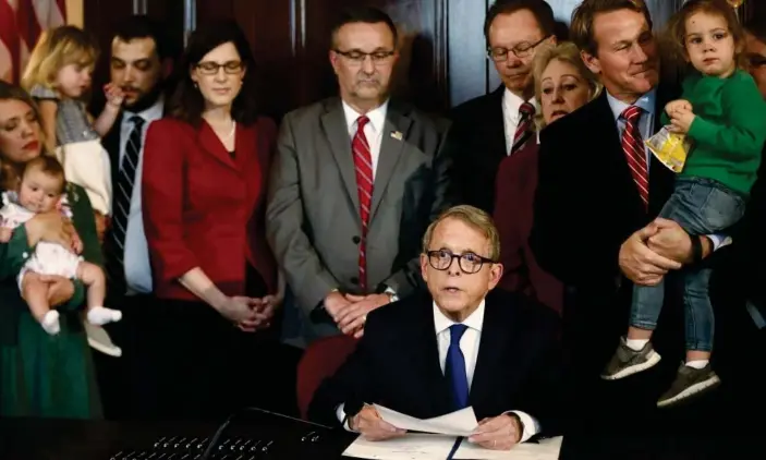  ?? Photograph: Fred Squillante/AP ?? Ohio abortion law: the Ohio governor, Mike DeWine, signs the ‘heartbeat bill’, one of the nation’s toughest abortion bans, on 11 April 2019.