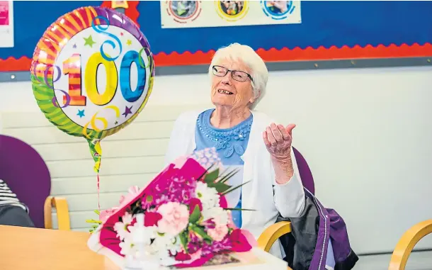  ??  ?? SAY IT WITH FLOWERS: Georgina Clancy was greeted with a bouquet as she returned on her 100th birthday yesterday. Picture by Steve Macdougall.