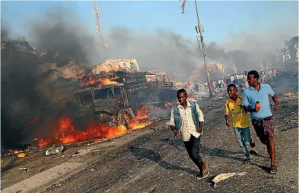  ??  ?? Civilians evacuate from the scene of an explosion in the Hodan district of Mogadishu.