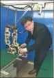  ?? LI WENFANG / CHINA DAILY ?? Huang Zhifeng adjusts his biped robot, which is able to take a big step while keeping its balance.