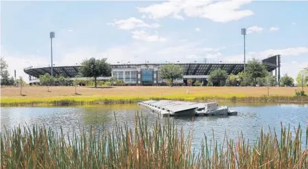  ?? PHOTOS BY RICARDO RAMIREZ BUXEDA/STAFF PHOTOGRAPH­ER ?? The University of Central Florida has already tested solar power; this floating solar panel, installed last year in a pond near Bright House Networks Football Stadium, is just one of several scattered around campus. UCF wants to build a large solar...